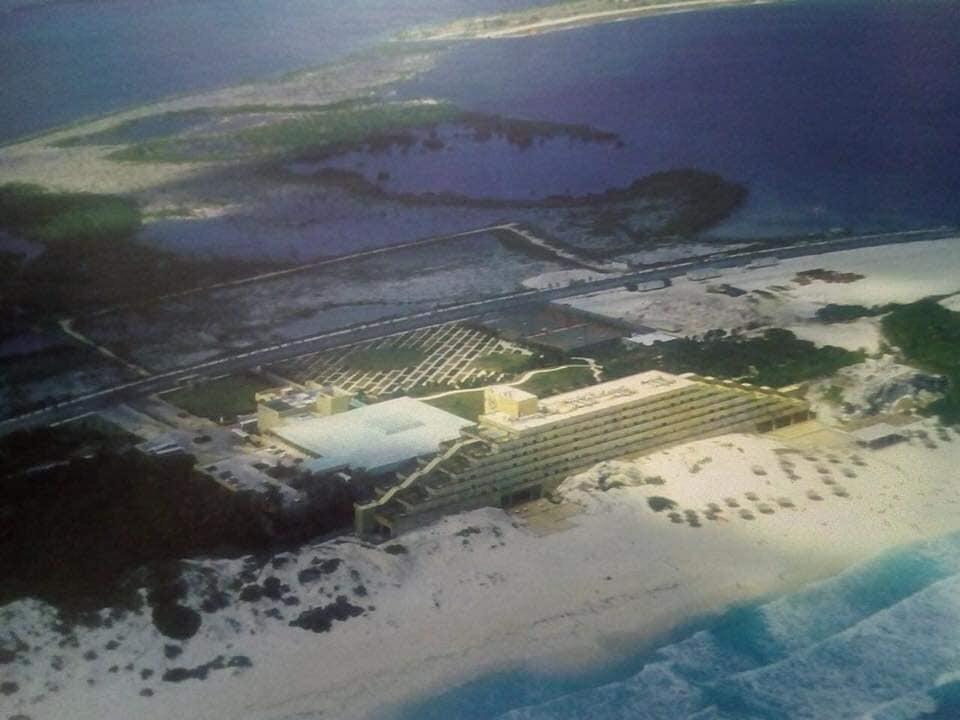 Aerial view of a beachfront hotel with the lagoon and the mangroves behind
